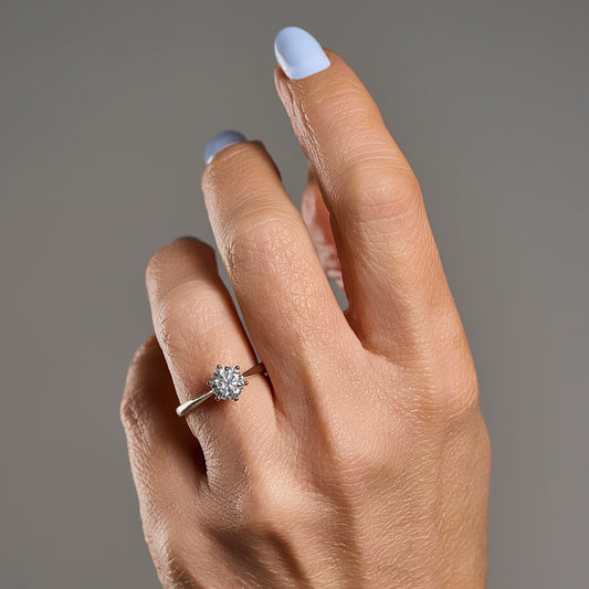 Woman wearing 1 ct brilliant cut moissanite solitaire ring in 925 sterling silver