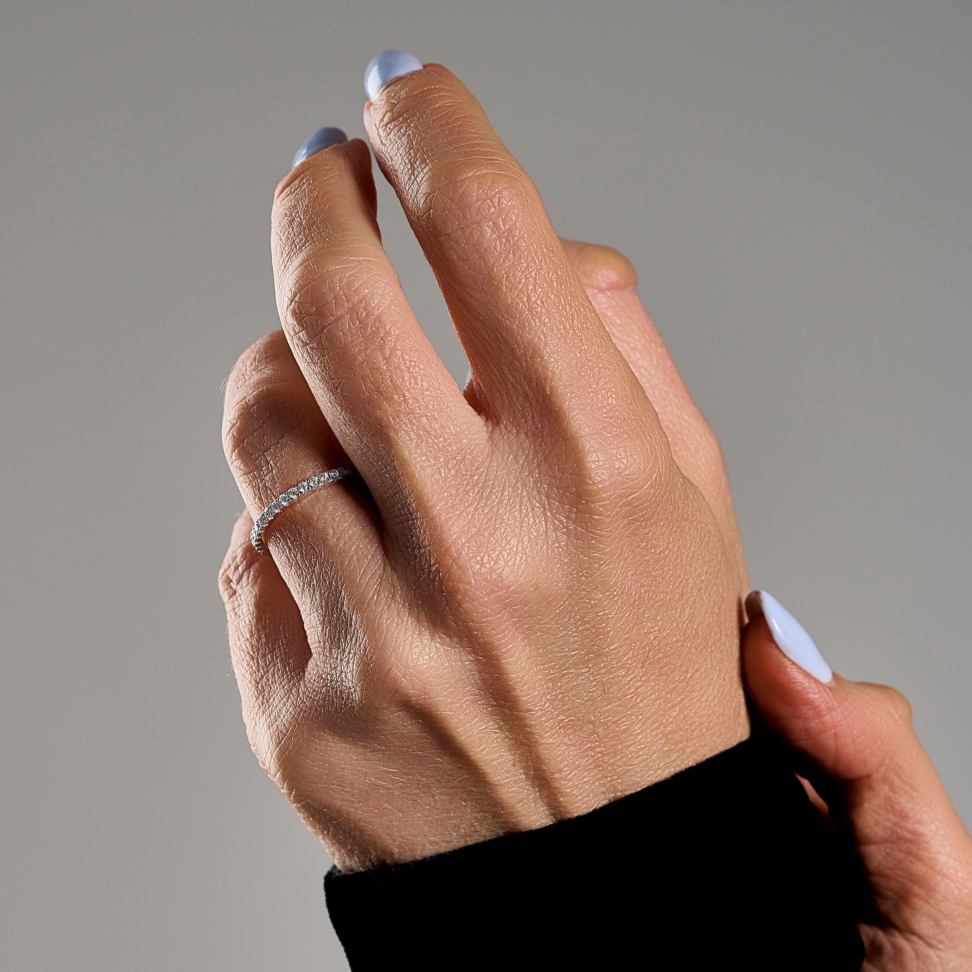 Woman wearing Veretta ring with brilliant cut moissanite stones in 925 sterling silver