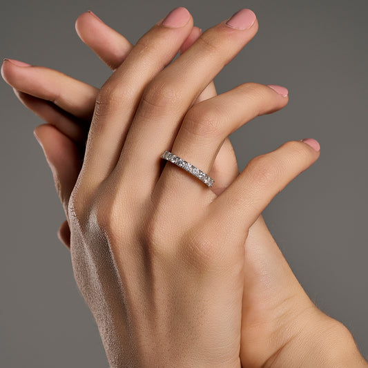 Woman wearing eternity ring with brilliant cut moissanite stones in 925 sterling silver