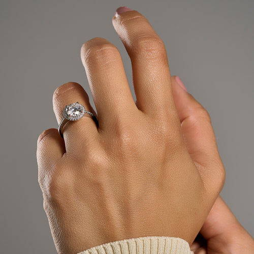 Woman wearing round halo moissanite ring with 2 ct brilliant cut center stone