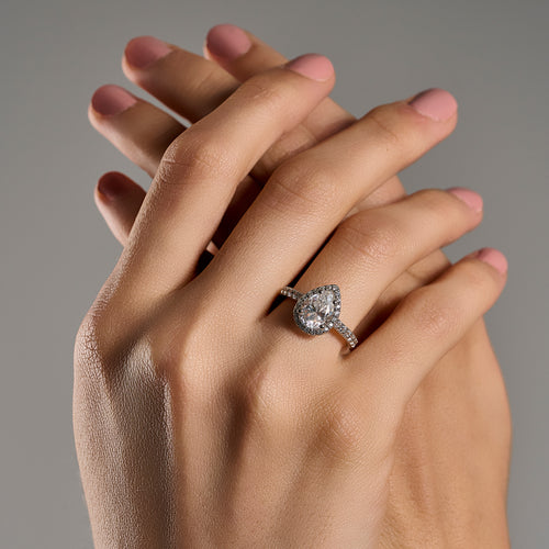 Woman wearing pear cut 2 ct moissanite halo ring in 925 sterling silver