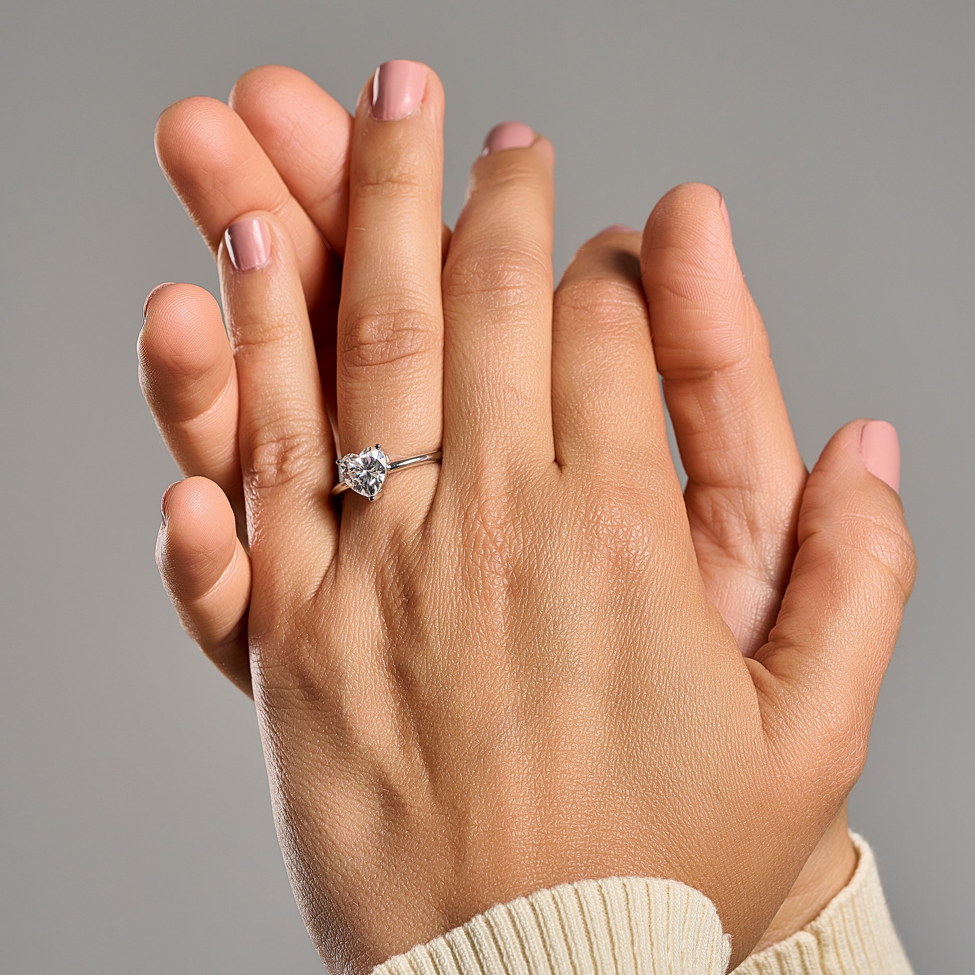 Woman wearing Cuore heart shaped emerald cut 2 ct moissanite ring in 925 sterling silver