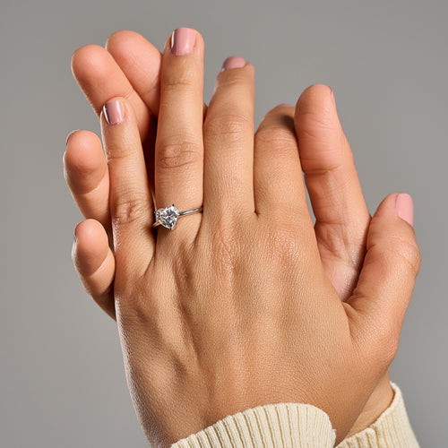 Woman wearing Cuore heart shaped emerald cut 2 ct moissanite ring in 925 sterling silver