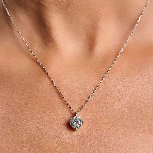 Close-up lifestyle image of a woman wearing a Light Point necklace with 2 ct round brilliant cut moissanite in 925 sterling silver.