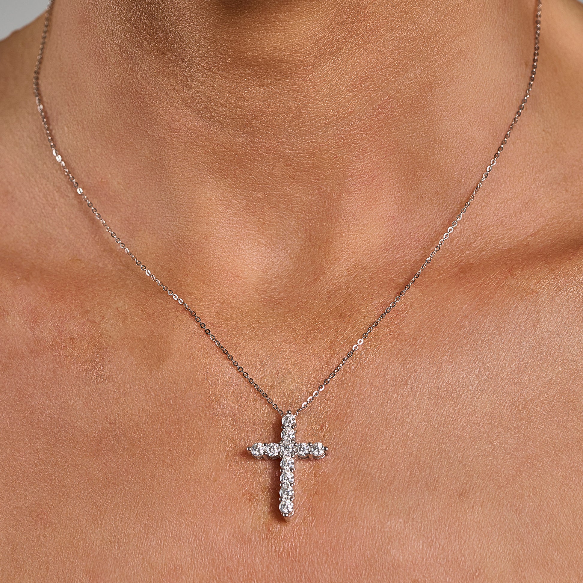 Model wearing a 3mm cross necklace with brilliant cut moissanite in 925 sterling silver.
