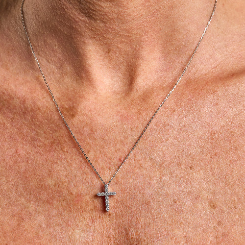 Model wearing a 2mm cross necklace with brilliant cut gemstones in 925 sterling silver.