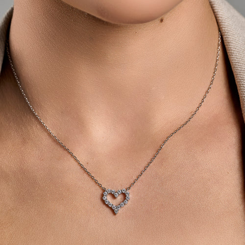 Model wearing a heart necklace with brilliant cut gemstones in 925 sterling silver.