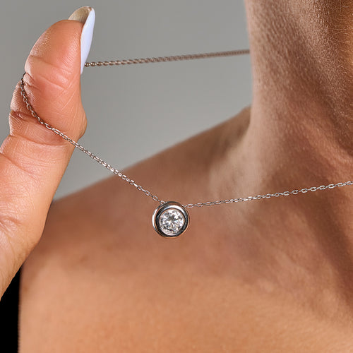 Close-up of a model wearing a light point necklace in 925 sterling silver with 1 ct brilliant cut moissanite and silver contour.