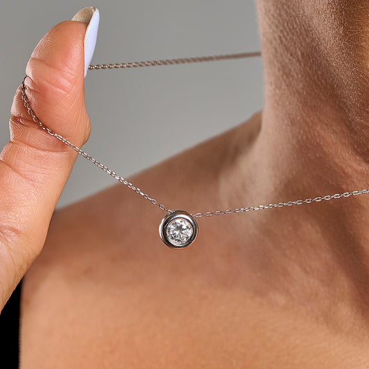 Close-up of a model wearing a light point necklace in 925 sterling silver with 1 ct brilliant cut moissanite and silver contour.