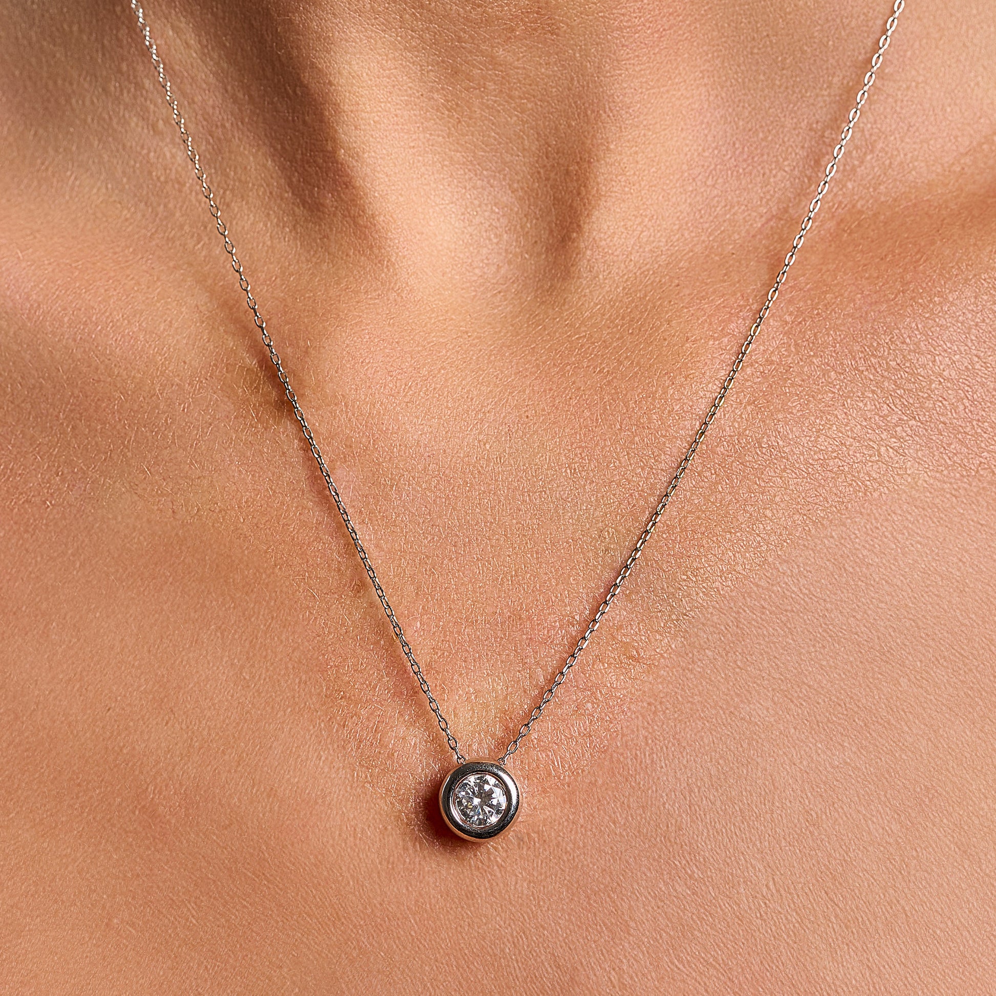 Model wearing a light point necklace in 925 sterling silver with 1 ct brilliant cut moissanite and silver contour.