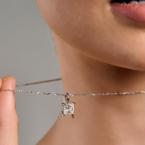 Model wearing a 925 sterling silver necklace with a 2 ct princess cut moissanite pendant in a close-up styling shot.