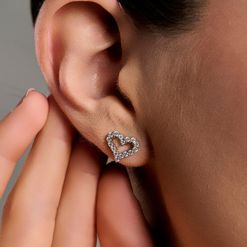 Woman wearing heart-shaped moissanite earrings in 925 sterling silver, showcasing a romantic open-heart design with brilliant sparkle.